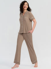Woman wearing a brown pajama set on a white background