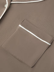 Close-up of a brown jacket with a pocket and white trim.