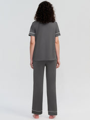 Person wearing gray pajamas with white trim on a light gray background