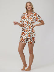 Woman wearing a leaf pajama set on a plain background