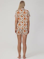 Woman wearing a leaf pajama set on a plain background