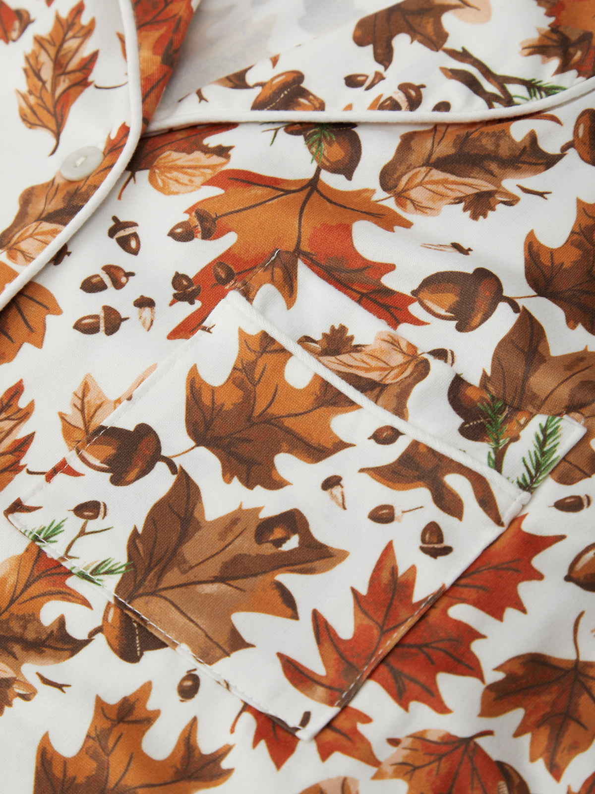 Fall-themed fabric with leaves and acorns on a white background
