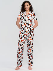 Woman wearing a pajama set with cat and pumpkin pattern on a white background