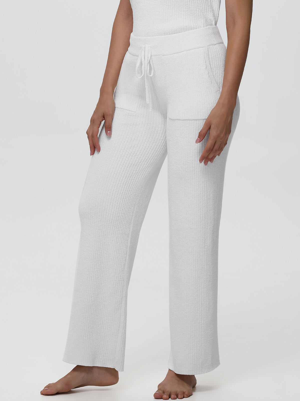 White ribbed lounge pants worn by a person on a white background