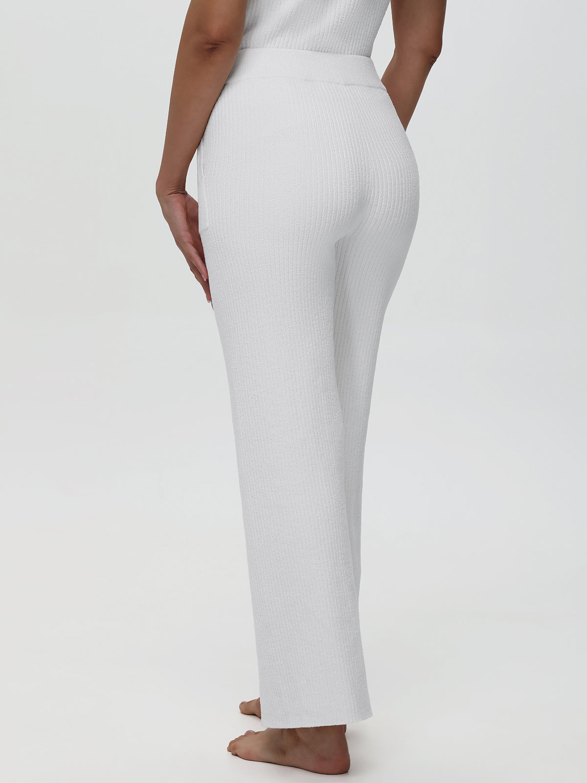 Person wearing white pants on a plain background