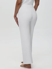 Person wearing white pants on a plain background