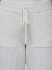 Close-up of white textured pants with a drawstring.