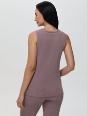 Woman wearing a sleeveless mauve top and pants on a light gray background