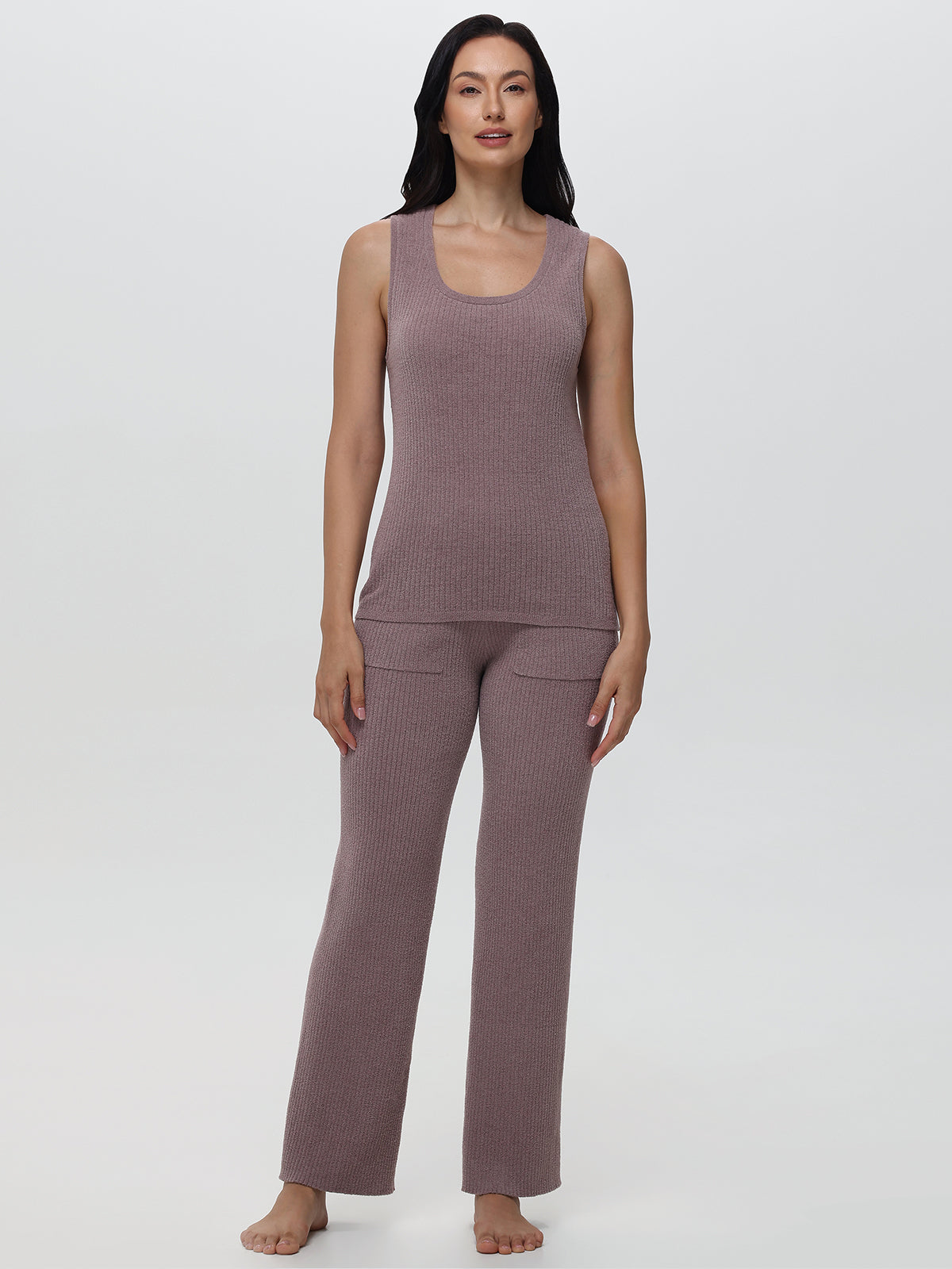 Woman wearing a mauve sleeveless top and pants on a white background