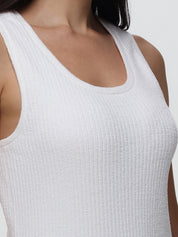White ribbed tank top worn by a person on a plain background