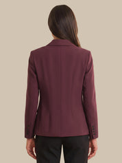 Maroon blazer worn by a person on a beige background