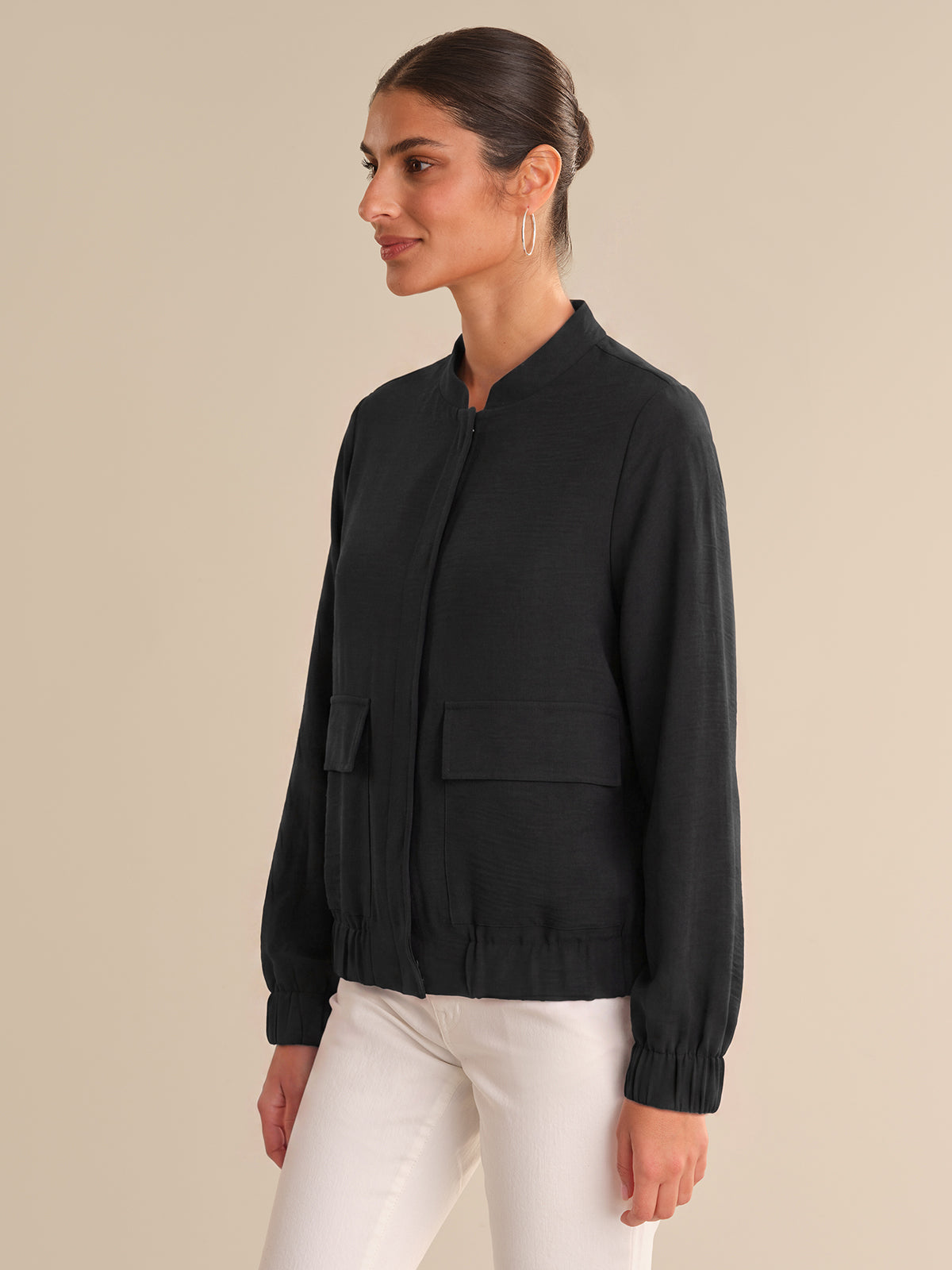 Woman wearing a black jacket with a neutral background