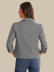 Woman wearing a black and white checkered jacket on a beige background