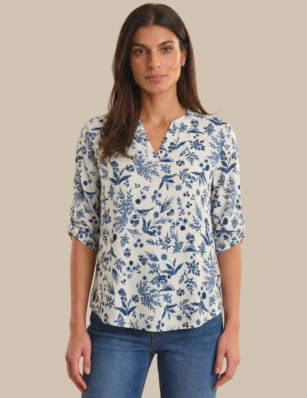 Woman wearing a blue floral blouse against a beige background
