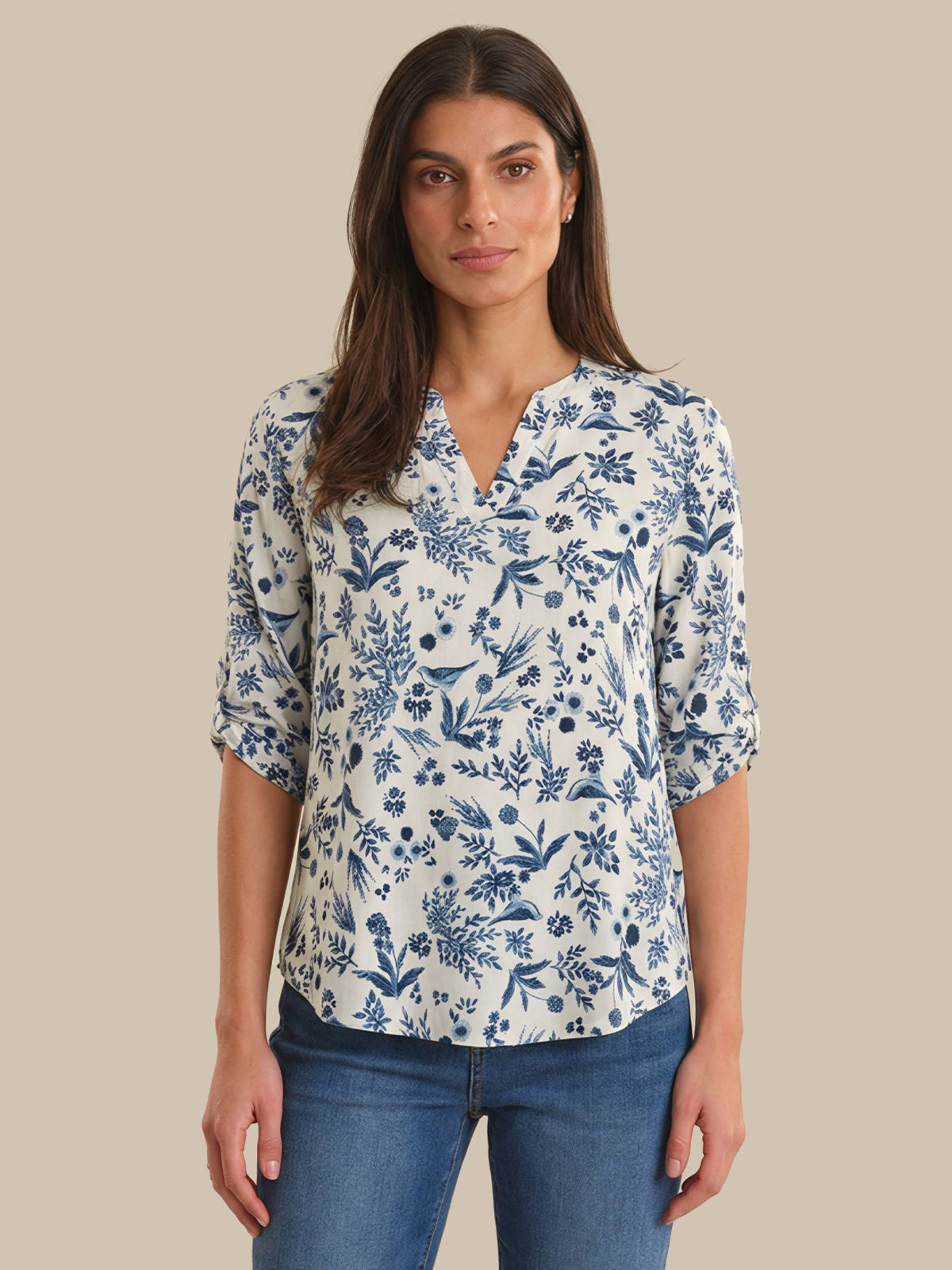 Woman wearing a blue floral blouse against a beige background