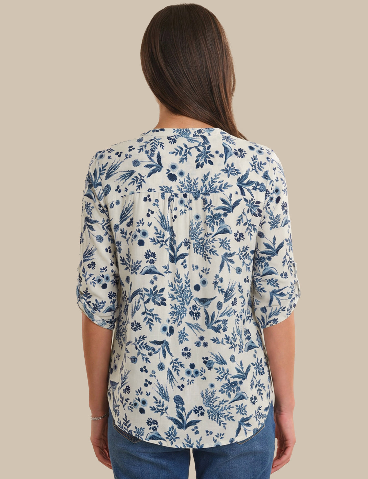 Woman wearing a blue floral patterned shirt on a beige background