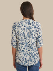 Woman wearing a blue floral patterned shirt on a beige background