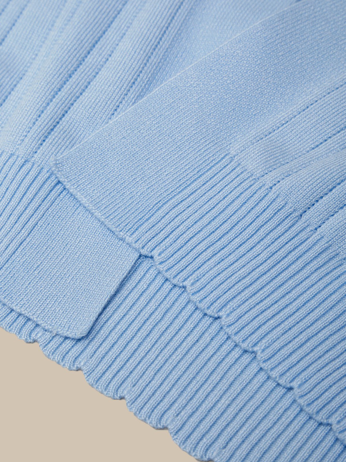 Close-up of a blue textured fabric with a beige background