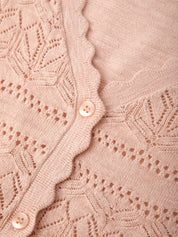 Close-up of a pink knitted cardigan with button details
