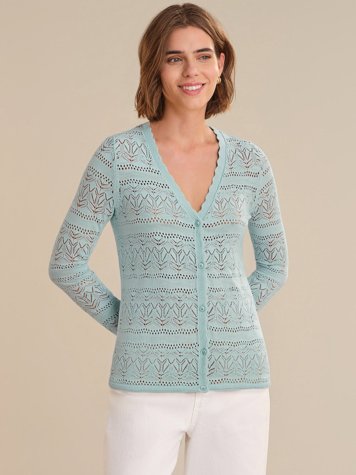 Woman wearing a light blue patterned sweater against a beige background