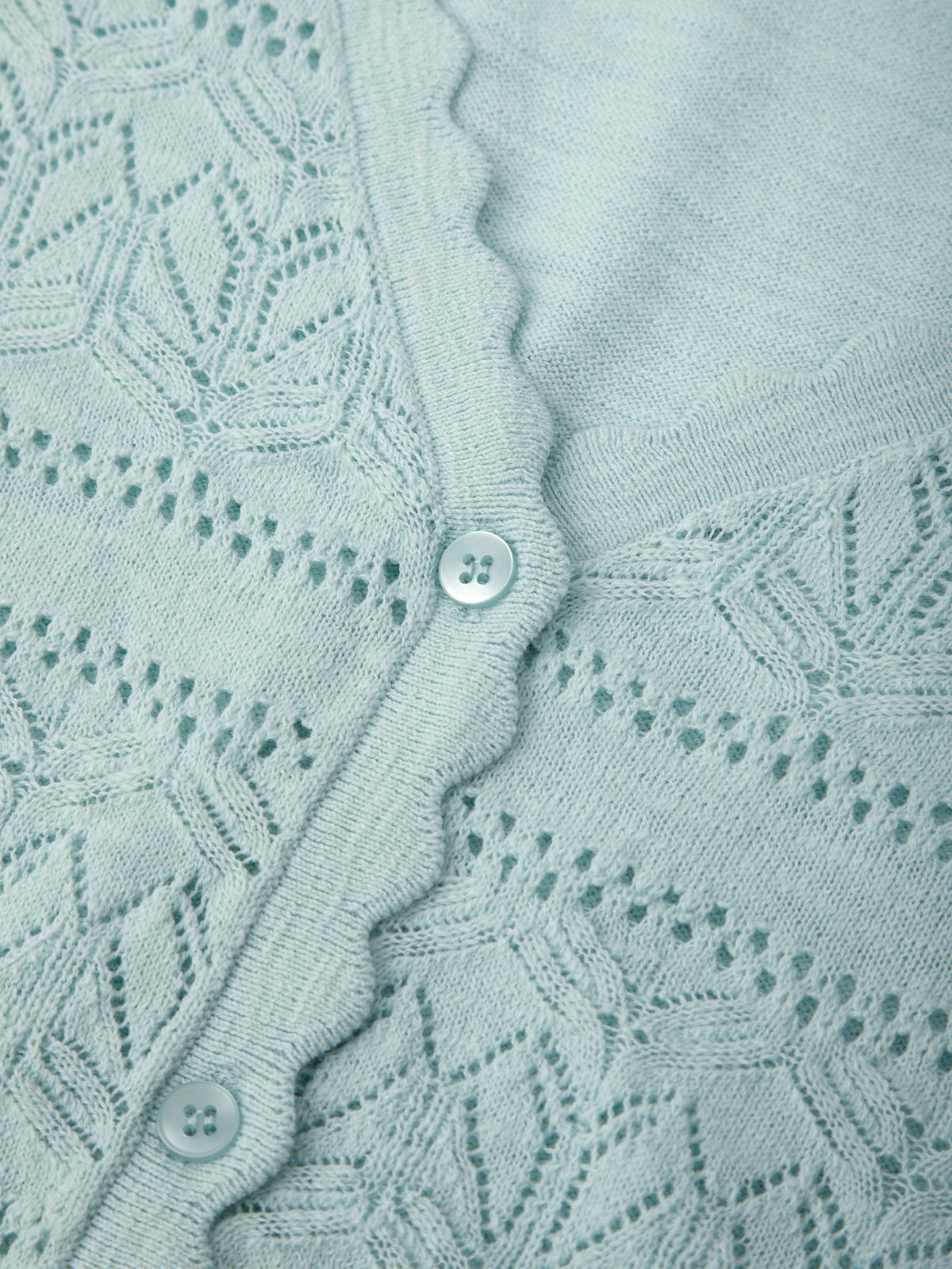 Close-up of a light blue knitted fabric with a button detail