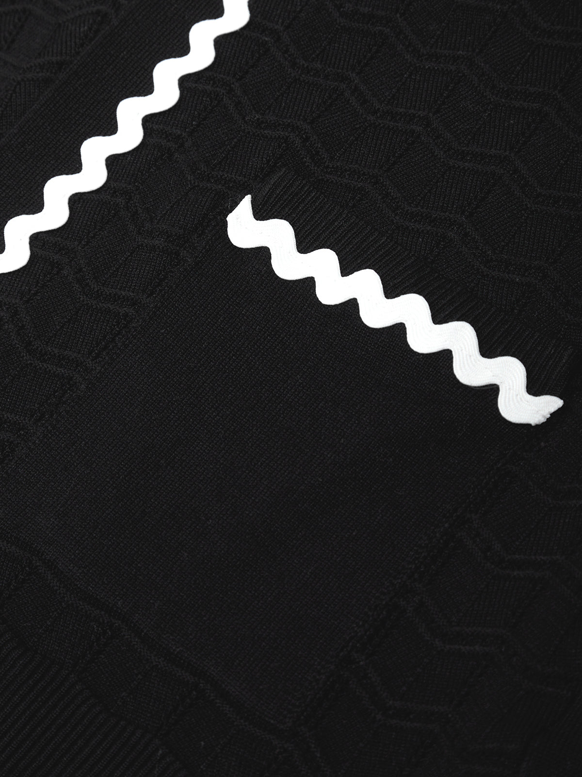 Close-up of a black sweater with white zigzag pattern
