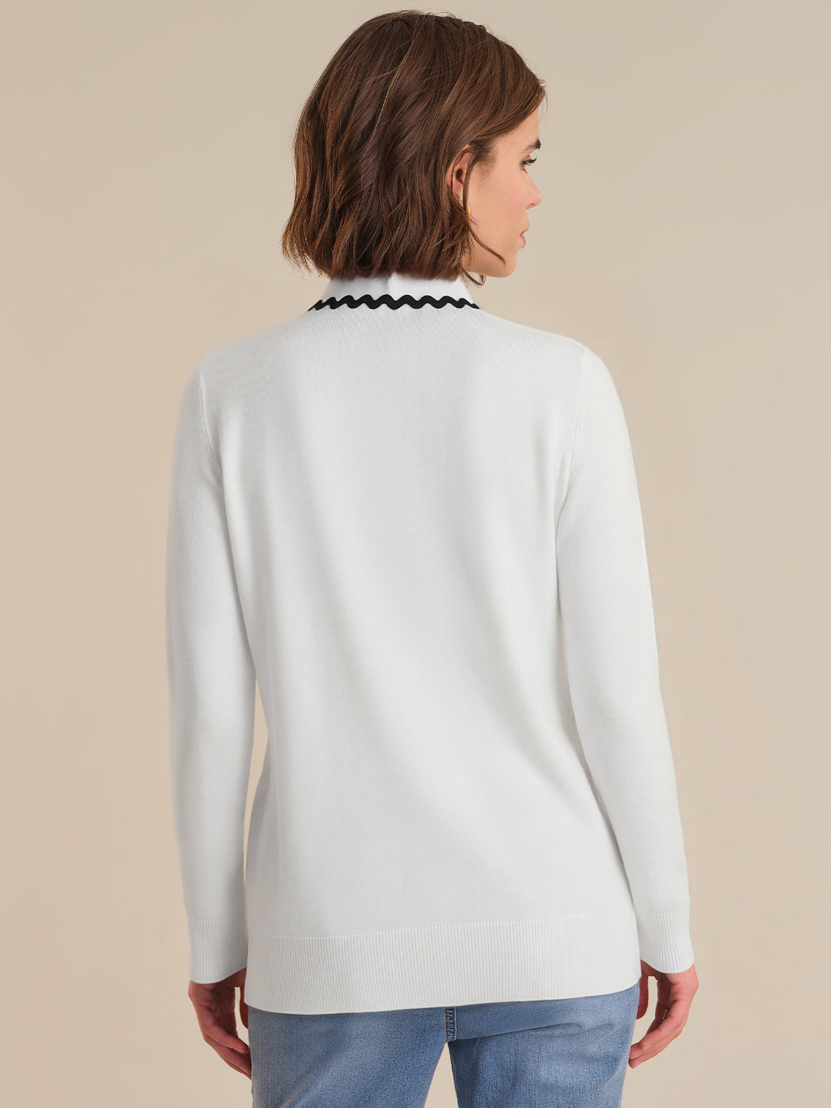 Woman wearing a white sweater with a white background