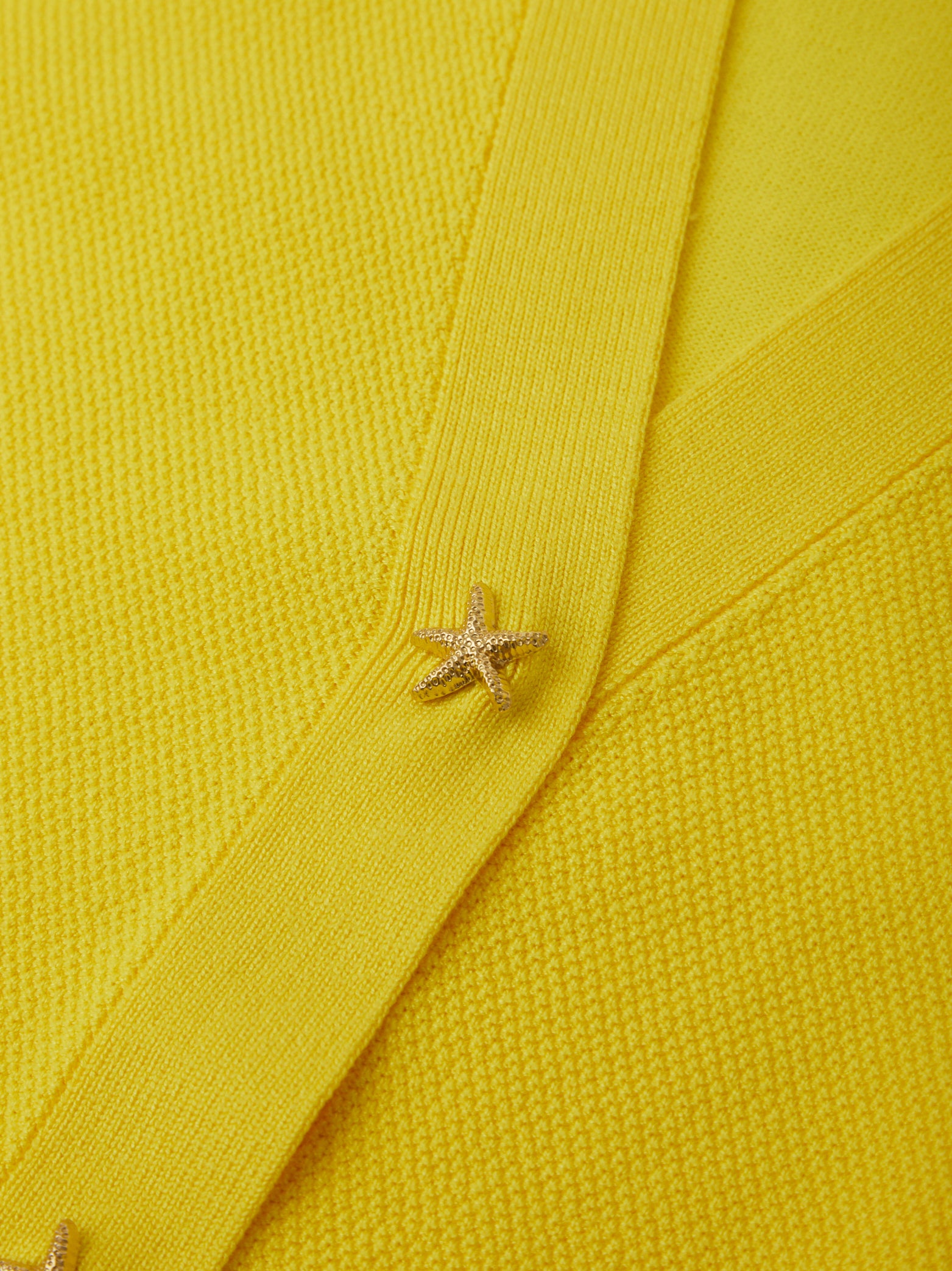 Close-up of a yellow fabric with a star-shaped button.