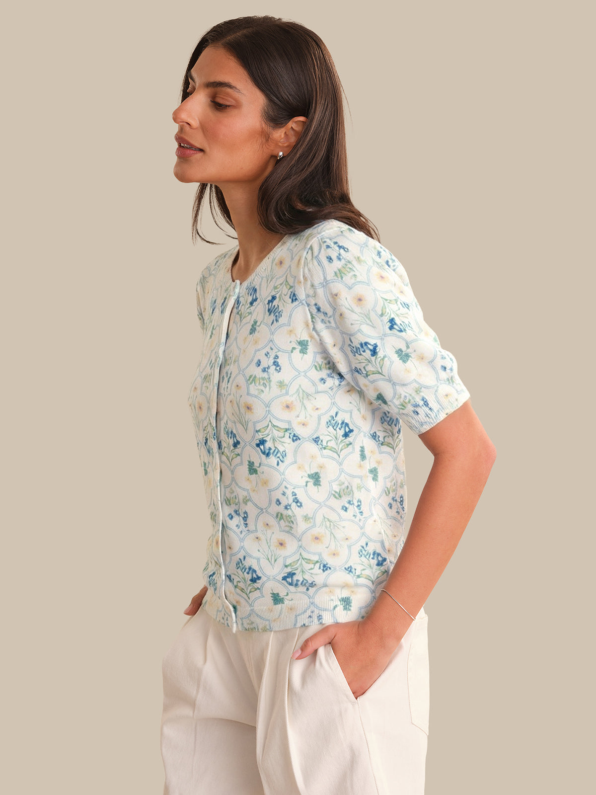 Woman wearing a floral cardigan with a neutral background