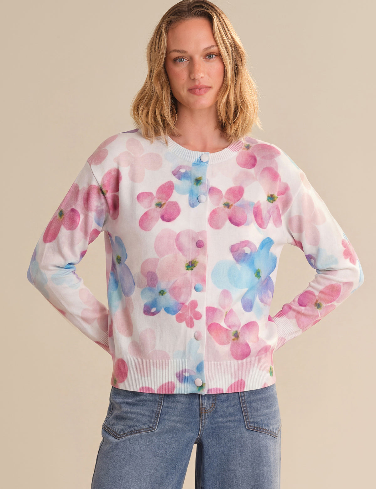 Woman wearing a floral cardigan with a beige background