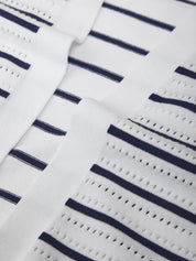 Close-up of a white fabric with navy blue stripes