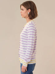 Woman wearing a striped sweater with a neutral background