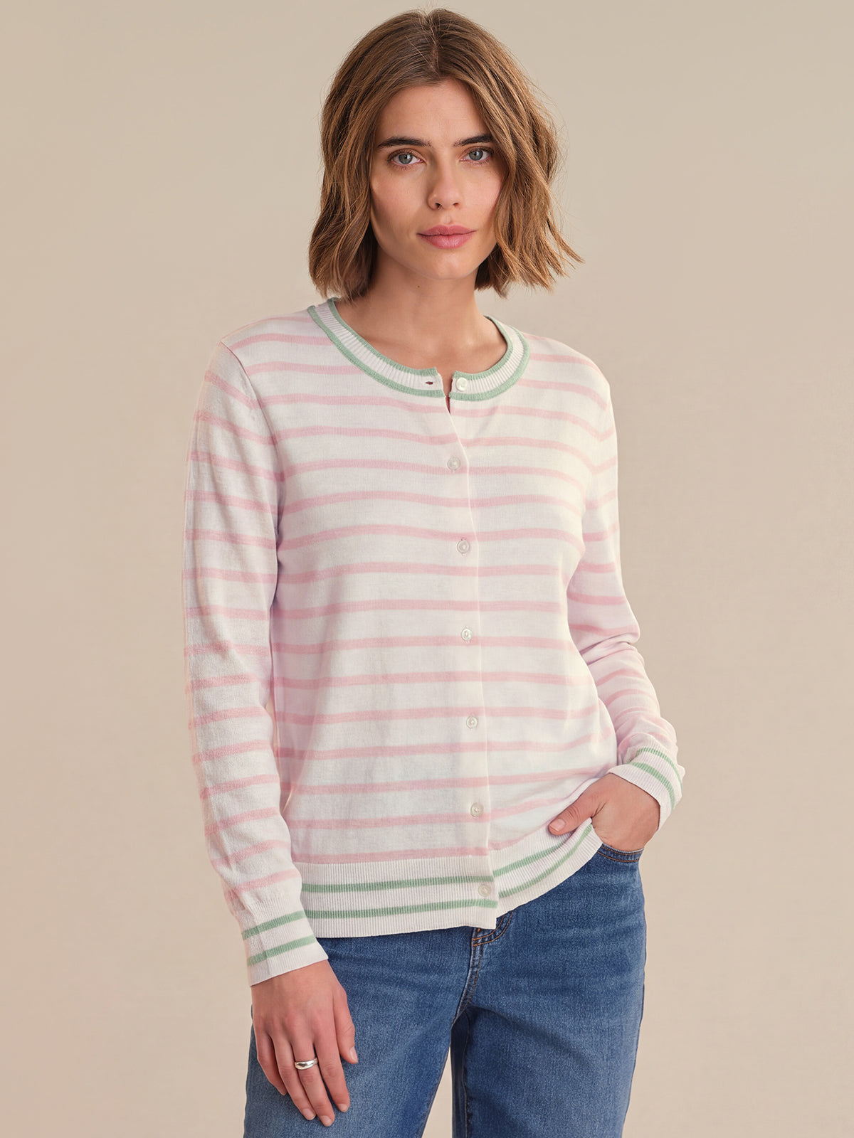 Woman wearing a striped sweater and jeans on a beige background
