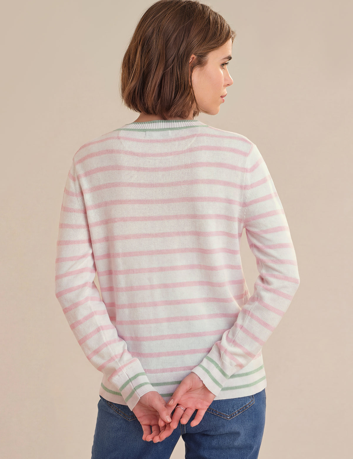 Woman wearing a striped sweater against a beige background