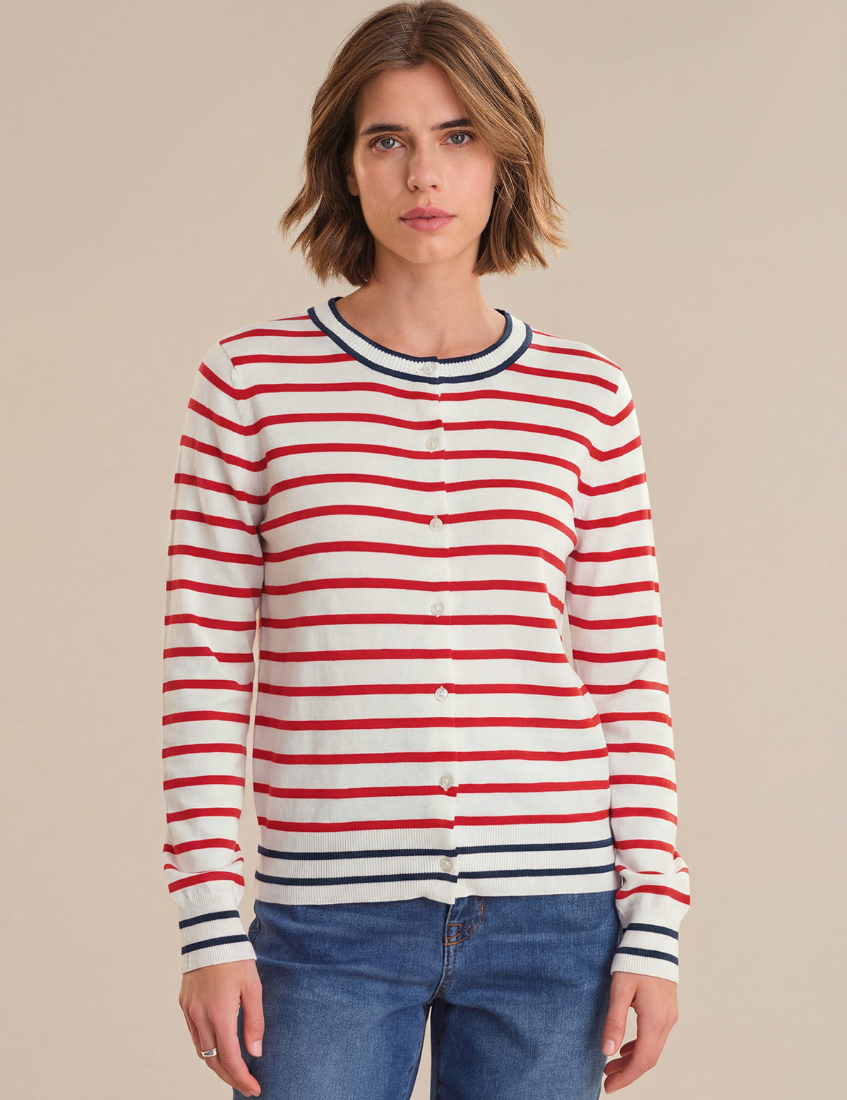 Woman wearing a red and white striped sweater with a beige background