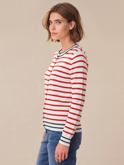 Woman wearing a red and white striped shirt against a beige background