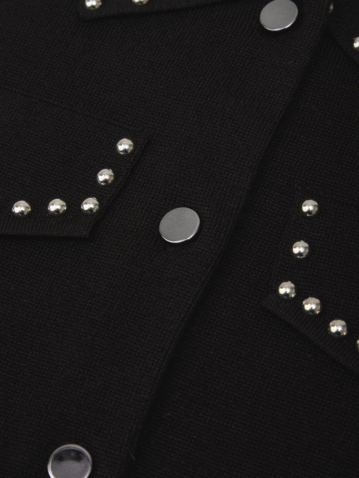 Close-up of a black jacket with silver studs and buttons.