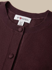Close-up of a dark burgundy knit cardigan with a button-down front and a visible neck label reading 89th & MADISON.