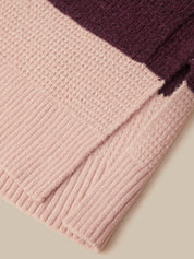 Close-up of a ribbed knit fabric in soft blush pink with a contrasting dark plum purple section, shown on a neutral beige background.
