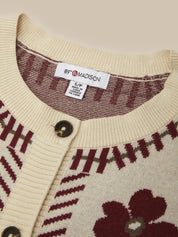Close-up of a cream-colored knit cardigan sweater with burgundy and olive green patterns, featuring a visible '89° MADISON' brand label inside the collar.