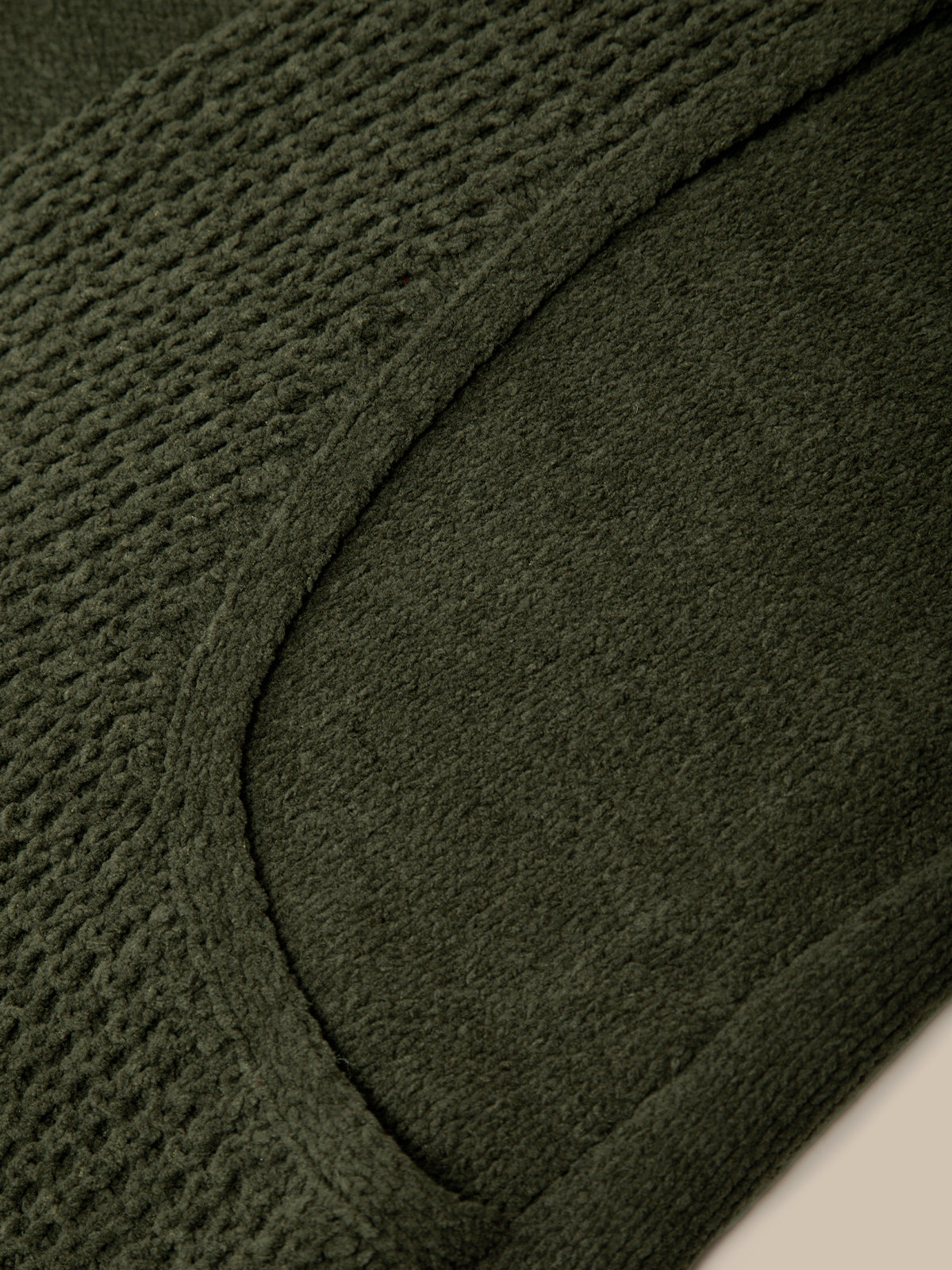 Close-up of a black coat with a brand label inside