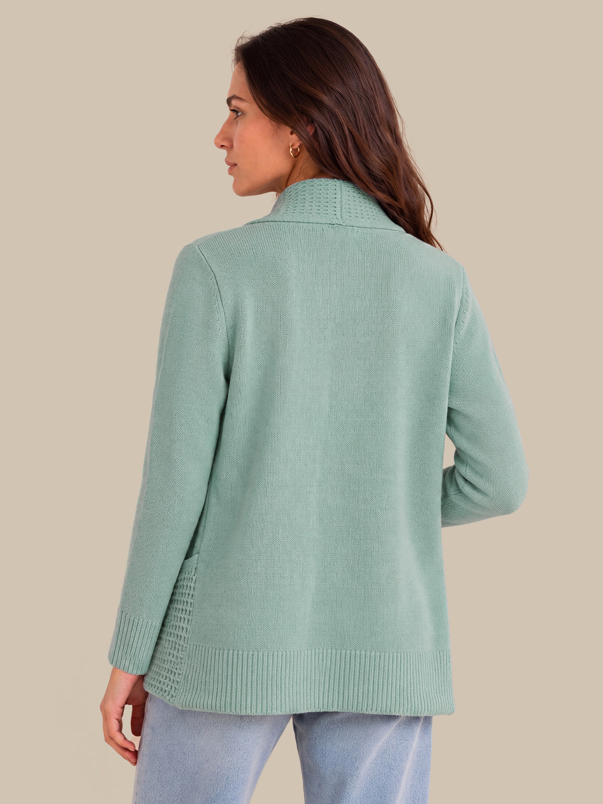 A woman shown from the back wearing a mint green knit cardigan with a mock neck and ribbed cuffs and hem, paired with light blue jeans, against a solid beige background.