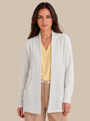 A woman modeling a lvory open-front cardigan with subtle speckled texture, worn over a yellow blouse and beige pants, against a solid beige background.