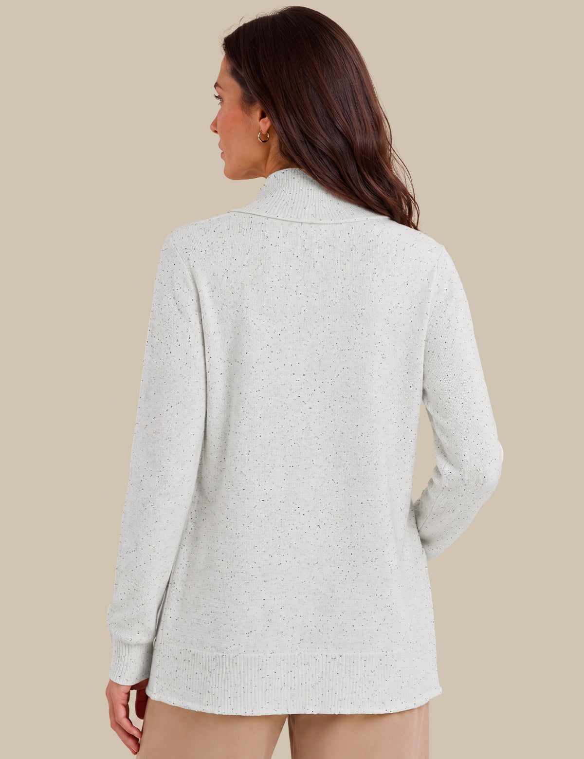 A woman shown from the back wearing a lvory knit sweater with a mock neck and long sleeves, set against a solid beige background.
