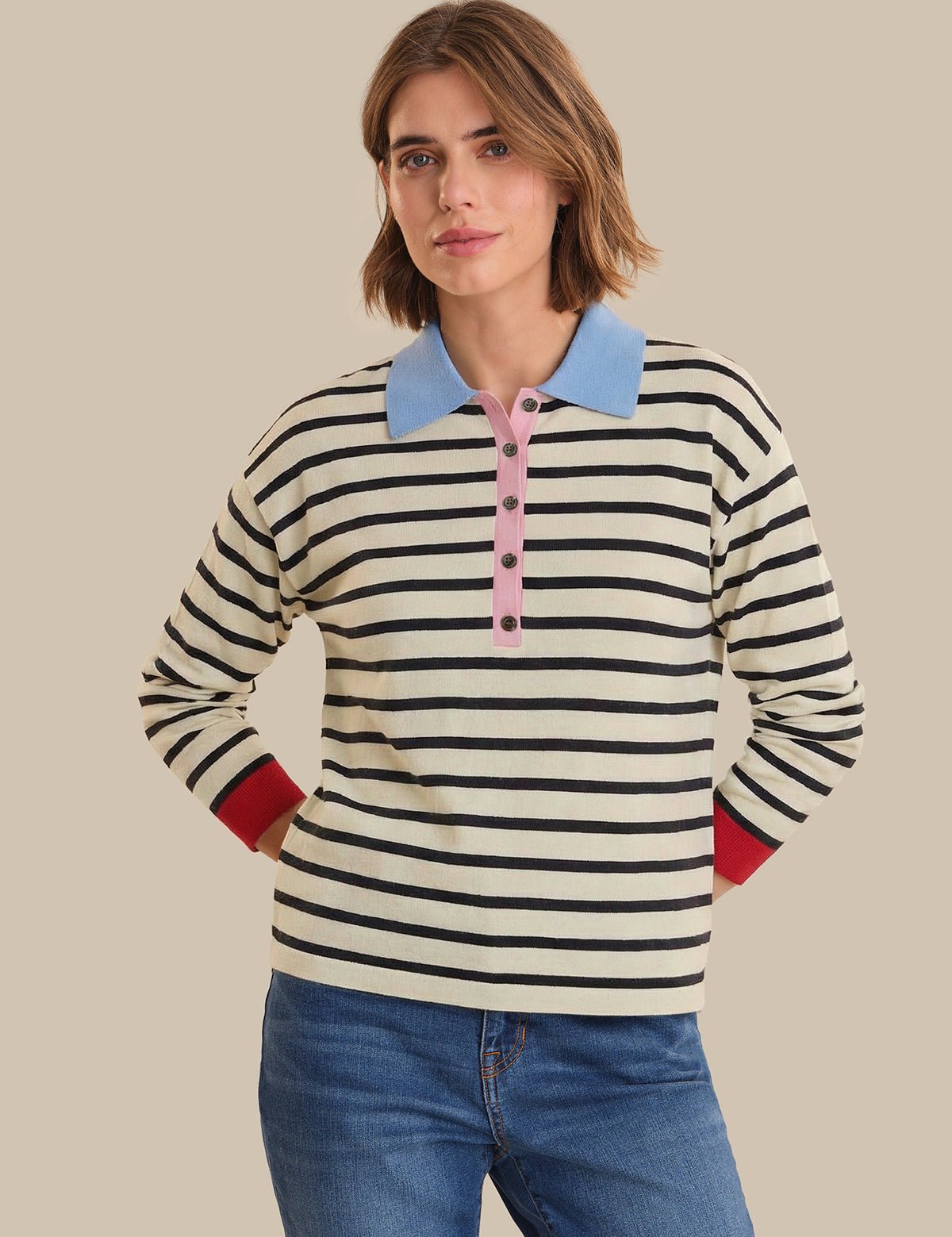 Person wearing a striped shirt with a blue collar and red accents on a beige background