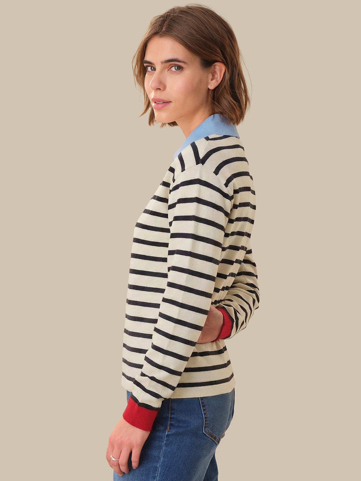 Woman wearing a striped sweater with a plain background