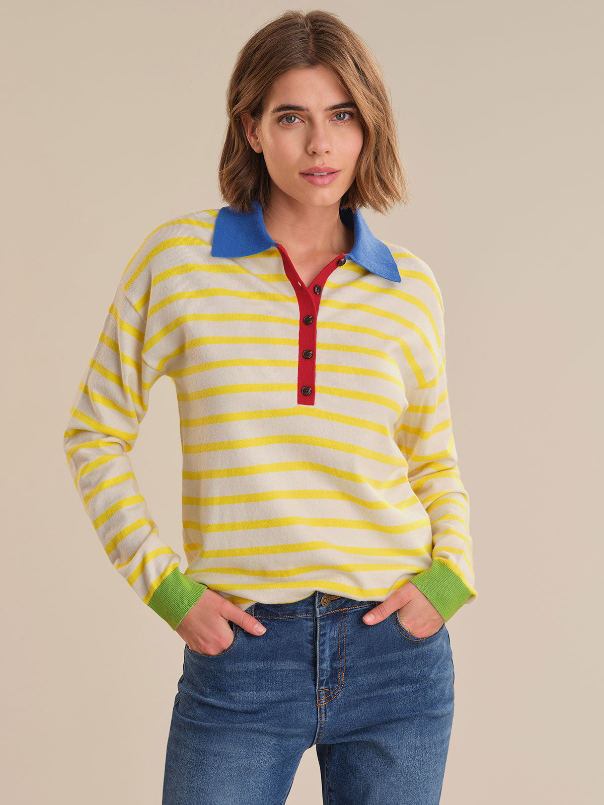 Woman wearing a striped shirt with a blue collar and red accents on a beige background