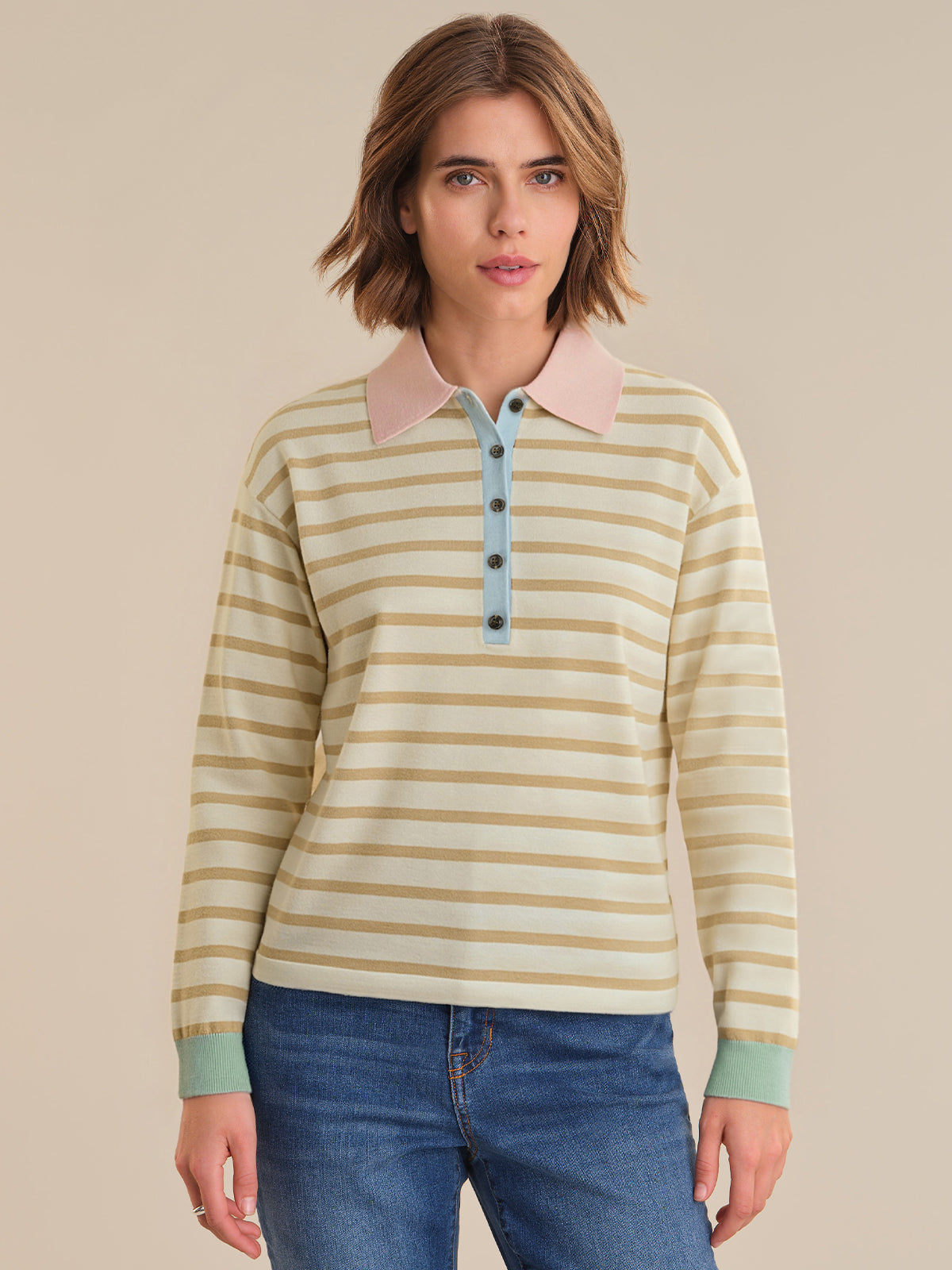 Woman wearing a striped long-sleeve shirt with a beige background