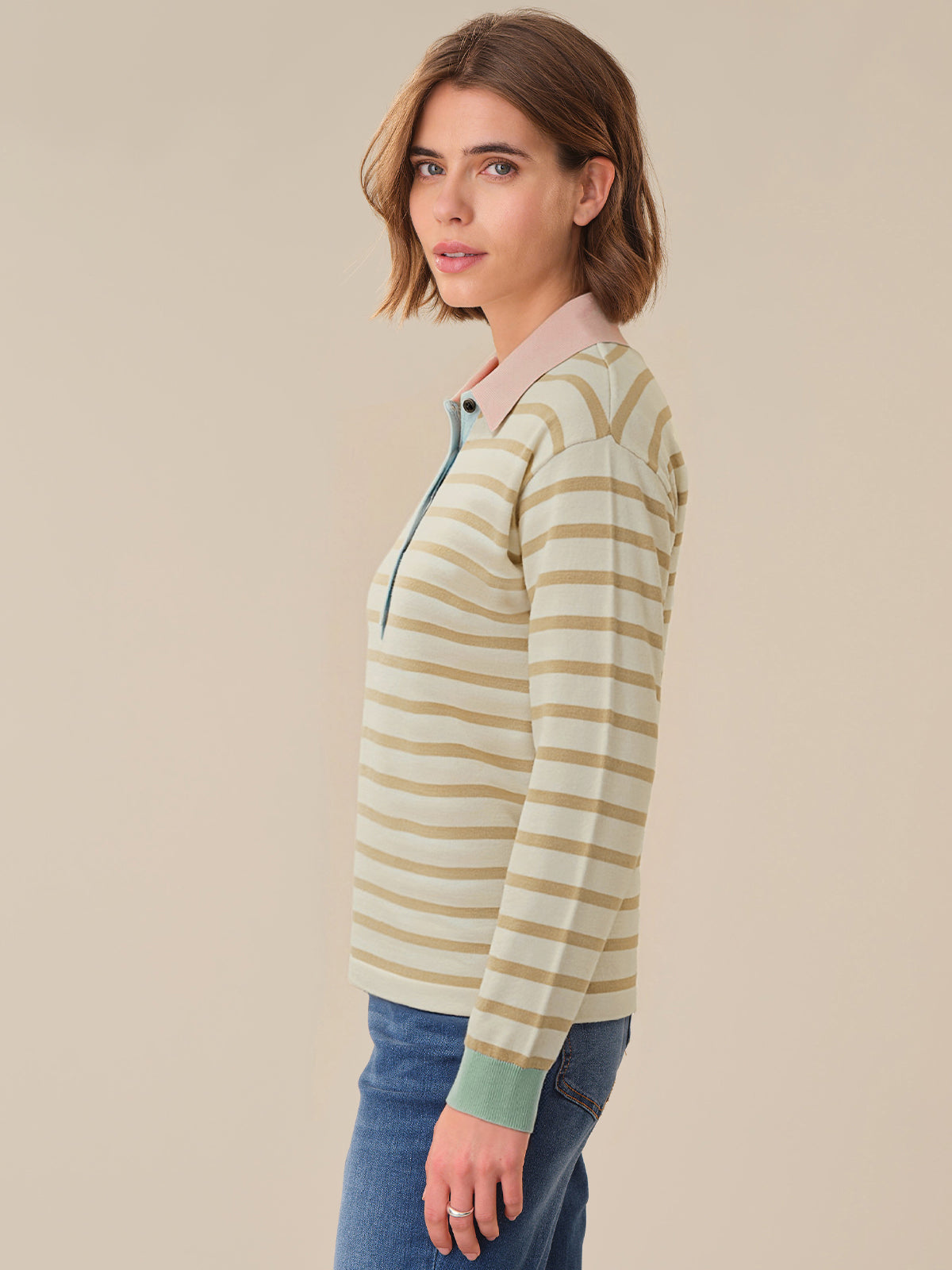Woman wearing a striped long-sleeve shirt with a beige background