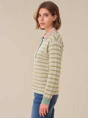 Woman wearing a striped long-sleeve shirt with a beige background
